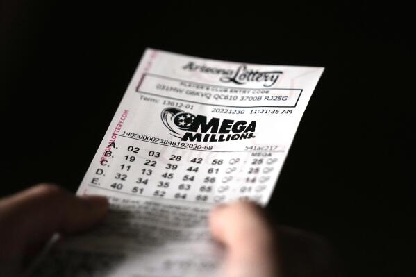 A person holds a Mega Millions lottery ticket in Tempe, Ariz., Friday, Dec. 30, 2022. The jackpot for the Friday drawing is estimated at $640 million. (AP Photo/Ross D. Franklin)