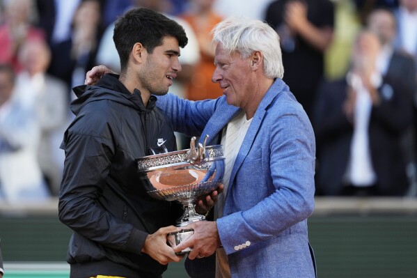 Winner Spain's Carlos Alcaraz, left, hugs with tennis star Bjorn Borg as he celebrates with the trophy after the men's final match of the French Open tennis tournament against Germany's Alexander Zverev at the Roland Garros stadium in Paris, Sunday, June 9, 2024. (AP Photo/Thibault Camus)