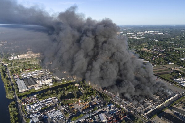 A fire burns from a vast shopping complex in Warsaw, Poland, on Sunday, May 12, 2024. The fire broke out Sunday morning in a vast shopping complex in the Polish capital that housed some 1,400 shops and service outlets and where many of the vendors were from Vietnam. (AP Photo/Norbert Ofmanski)