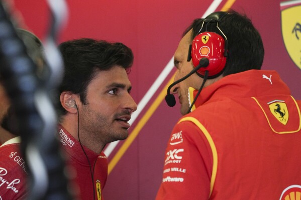 Ferrari driver Carlos Sainz, left, of Spain talks with a teammate following the first practice session of the Australian Formula One Grand Prix at Albert Park, in Melbourne, Australia, Friday, March 22, 2024. (AP Photo/Asanka Brendon Ratnayake)