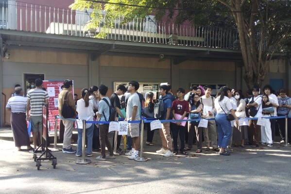 People wait in line to enter into the Thai Embassy for visa appointments in Yangon, Myanmar, Tuesday, Feb. 20, 2024. Crowds of people have thronged to get passports and visas to neighboring Thailand in the two weeks since the government activated a law making at least 14 million young people subject to conscription.(AP Photo)