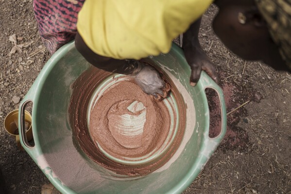 Sadio Camara, a gold processor, mixes mercury into sediment without using protective equipment at her home in the Kedougou region of Senegal on Thursday, Jan. 16, 2025. (AP Photo/Annika Hammerschlag)