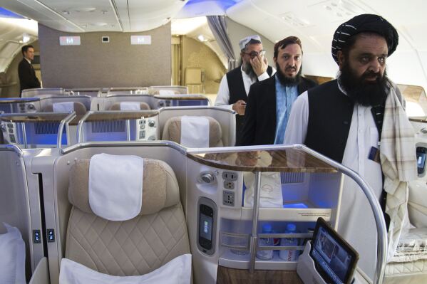 Afghan Taliban Envoy to the United Arab Emirates Badruddin Haqqani, far right, walks through an Emirates A380's business class on display at the Dubai Air Show in Dubai, United Arab Emirates, Monday, Nov. 13, 2023. The biennial Dubai Air Show opened Monday as airlines are poised to make major aircraft purchases after rebounding from the groundings of the coronavirus pandemic, even as Israel's war with Hamas clouds regional security. (AP Photo/Jon Gambrell)