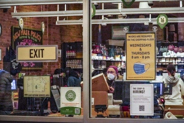 Signs posted at Brooklyn's Park Slope Co-Op grocery store, remind shoppers to mask-up Wednesdays and Thursdays as a policy, Thursday, Dec. 7, 2023, in New York. (AP Photo/Bebeto Matthews)