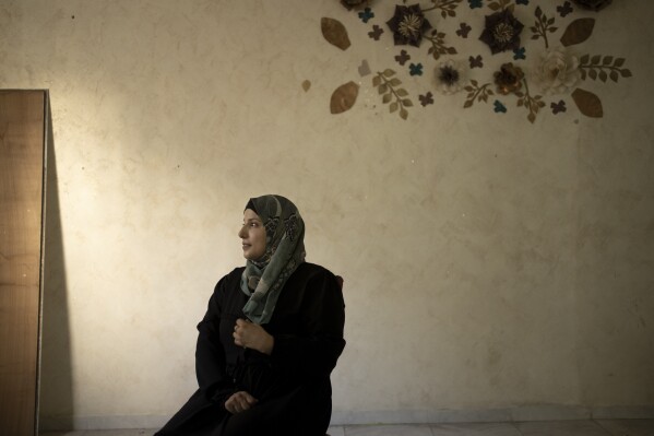 Fida Zalabani, mother of Mohammed Zalabani, a 13 year-old Palestinian in juvenile detention, awaiting trial on murder charges for a Feb. 13 stabbing attack, sits for an interview in the family's emptied apartment which is slated to be demolished by Israeli authorities in the Shuafat refugee camp in east Jerusalem, Wednesday, Aug. 30, 2023. An Israeli court last week dismissed the family's appeal and decided to destroy their home of nearly three years in Shuafat refugee camp, a crowded and garbage-strewn district of east Jerusalem, as further punishment. The demolition could occur anytime in the coming days. (AP Photo/Maya Alleruzzo)