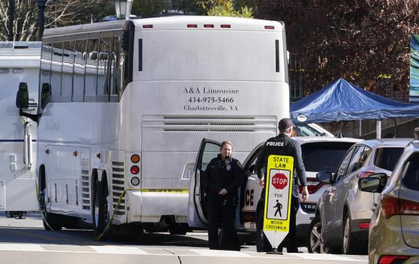 Police investigators work around a bus which is believed to be the site of an overnight shooting on the grounds of the University of Virginia Monday, Nov. 14, 2022 in Charlottesville. Va. (AP Photo/Steve Helber)