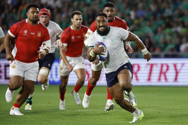 Ireland's Bundee Aki runs with the ball before scoring a try during the Rugby World Cup Pool B match between Ireland and Tonga at the Stade de la Beaujoire in Nantes, France, Saturday, Sept. 16, 2023. (AP Photo/Jeremias Gonzalez)