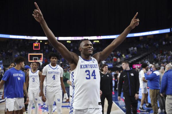 FILE - Kentucky's Oscar Tshiebwe (34) celebrates after defeating North Carolina following an NCAA college basketball game, Saturday, Dec. 18, 2021, in Las Vegas. Tshiebwe is the unanimous pick as The Associated Press player of the year in the Southeastern Conference, announced Tuesday, March 8, 2022.(AP Photo/Joe Buglewicz, File)