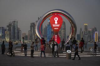 ARCHIVO - Foto del 25 de noviembre del 2021, la gente se reúne junto al reloj de cuenta regresiva a la Copa Mundial en Doha, Qatar. (AP Foto/Darko Bandic, Archivo)