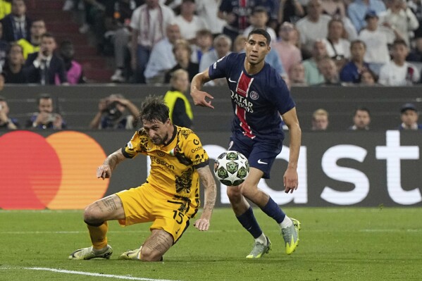 PSG's Achraf Hakimi, right, is challenged by Inter Milan's Francesco Acerbi during the Champions League final soccer match between Paris Saint-Germain and Inter Milan at the Allianz Arena in Munich, Germany, Saturday, May 31, 2025. (AP Photo/Martin Meissner)