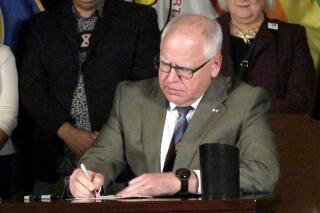 Minnesota Gov. Tim Walz signs a ban on so-called conversion therapy during a ceremony at the State Capitol in St. Paul, Minn., on Thursday, July 15, 2021. Walz said conversion therapy, the scientifically discredited practice of using therapy to "convert" LGBTQ people to heterosexuality or traditional gender expectations, is a "byzantine, tortuous practice." He said his order empowers state agencies to ensure that no Minnesotans under age 18 are subjected to it, and that insurance companies and state health plans don't cover it. (AP Photo/Steve Karnowski)