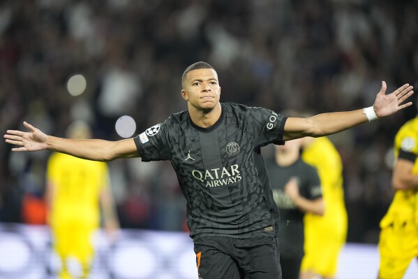 PSG's Kylian Mbappe celebrates after scoring his side's opening goal from a penalty shot during the Champions League group F soccer match between Paris Saint-Germain and Borussia Dortmund, at the Parc des Princes stadium in Paris, France, Tuesday, Sept. 19, 2023. (AP Photo/Michel Euler)