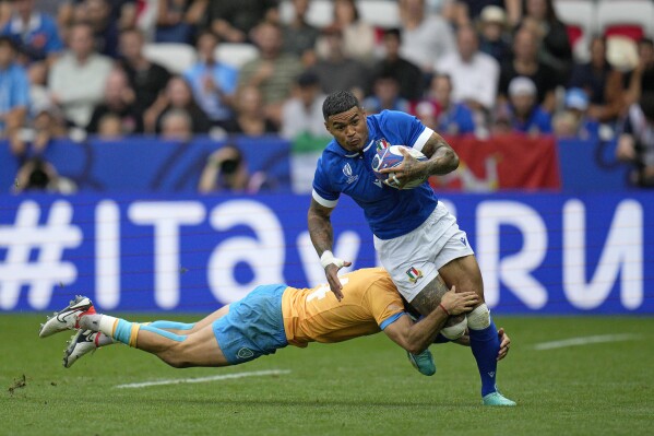 Italy's Montanna Ioane is tackled by Uruguay's Gaston Mieres during the Rugby World Cup Pool A match between Italy and Uruguay at the Stade de Nice, in Nice, Wednesday, Sept. 20, 2023. (AP Photo/Daniel Cole)
