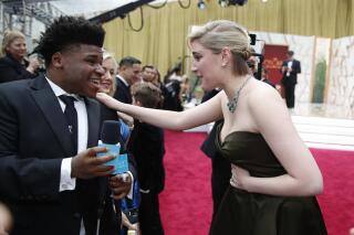 FILE - Greta Gerwig, right, talks to Jerry Harris on the red carpet at the Oscars at the Dolby Theatre in Los Angeles, Feb. 9, 2020. Former “Cheer” star Jerry Harris has pleaded guilty to felony child pornography and child sex charges in federal court. The 22-year-old Harris entered his plea on Thursday, Feb. 10, 2022 to receiving child pornography and traveling with the intent to engage in illicit sexual conduct. (AP Photo/John Locher File)