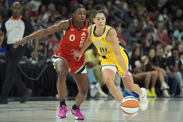 Los Angeles Sparks guard Kelsey Plum (10) drives against Las Vegas Aces guard Jackie Young (0) during the first half of a WNBA basketball game Friday, May 30, 2025, in Las Vegas. (AP Photo/John Locher)