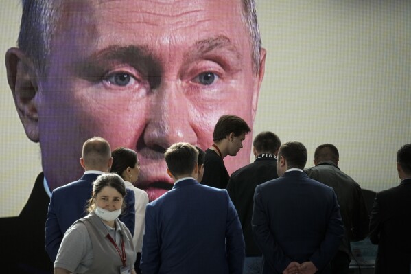 FILE - Participants watch Russian President Vladimir Putin's addressing a plenary session of the St. Petersburg International Economic Forum in St.Petersburg, Russia, Friday, June 17, 2022. Most Russian opposition figures are either in prison at home or are in exile abroad. But they vow that they will still put up a fight against President Vladimir Putin as he seeks yet another term in office in an election scheduled for March. (AP Photo, File)