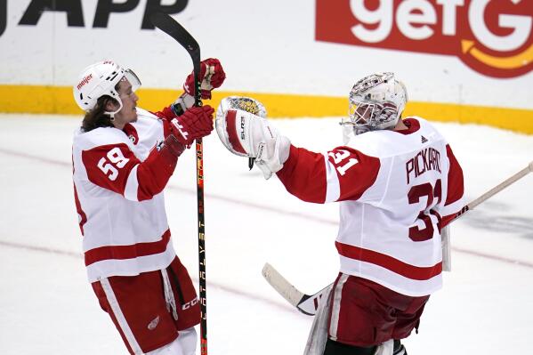 Detroit Red Wings goaltender Calvin Pickard (31) celebrates with Tyler Bertuzzi (59) after a shootout win over the Pittsburgh Penguins in an NHL hockey game in Pittsburgh, Friday, Jan. 28, 2022. (AP Photo/Gene J. Puskar)
