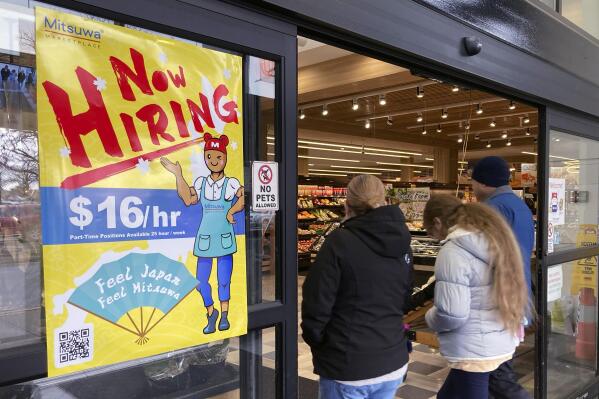 FILE - A hiring sign is displayed at a grocery store in Arlington Heights, Ill., Friday, Jan. 13, 2023. A strong job market has helped fuel the inflation pressures that have led the Federal Reserve to keep raising interest rates. (AP Photo/Nam Y. Huh, File)