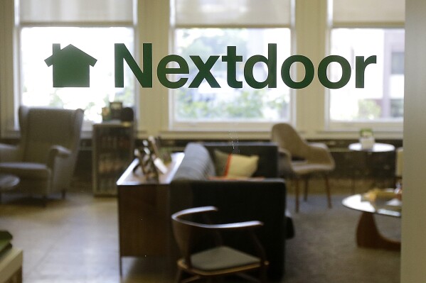 FILE - A Nextdoor sign is shown in a window at an office in San Francisco, May 11, 2016. Two Pinterest directors resigned from Nextdoor's board of directors earlier this month, the U.S. Justice Department said Wednesday, Aug. 16, 2023, amid the agency's broader efforts to enforce antitrust law aimed at barring executives from holding similar positions at rival companies. (AP Photo/Jeff Chiu, File)