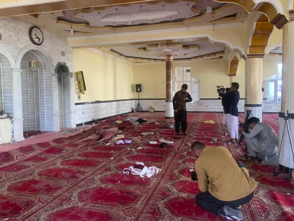Afghan journalist take photos and film inside a mosque after a bomb explosion in Shakar Dara district of Kabul, Afghanistan, Friday, May 14, 2021. A bomb ripped through a mosque in northern Kabul during Friday prayers killing 12 worshippers, Afghan police said. (AP Photo/Rahmat Gul)