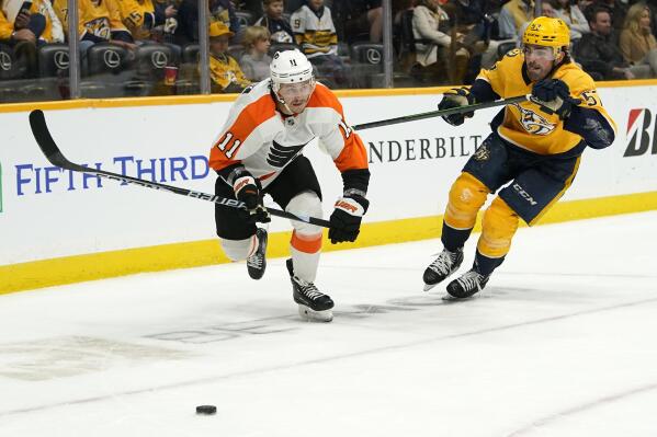 Philadelphia Flyers' Travis Konecny (11) and Nashville Predators' Dante Fabbro (57) chase the puck in the third period of an NHL hockey game Saturday, Oct. 22, 2022, in Nashville, Tenn. (AP Photo/Mark Humphrey)