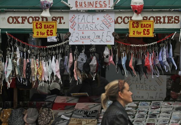 A shop sells face masks on Oxford Street in London, Tuesday, Oct. 13, 2020. Unemployment across the U.K. rose sharply higher in August which is a clear indication that the jobless rate is set to spike higher when a government salary-support scheme ends this month and new restrictions are imposed on local areas to suppress a resurgence of the coronavirus.(AP Photo/Frank Augstein)