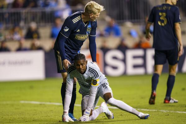 Philadelphia Union's Andre Blake, front bottom, gets helped up by Jakob Glesnes, front top, during the first half of an MLS playoff soccer match against FC Cincinnati, Thursday, Oct. 20, 2022, in Chester, Pa. (AP Photo/Chris Szagola)