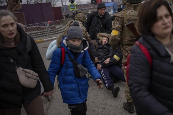As artillery echoes nearby, people flee Irpin on the outskirts of Kyiv, Ukraine, Monday, March 7, 2022. (AP Photo/Emilio Morenatti)