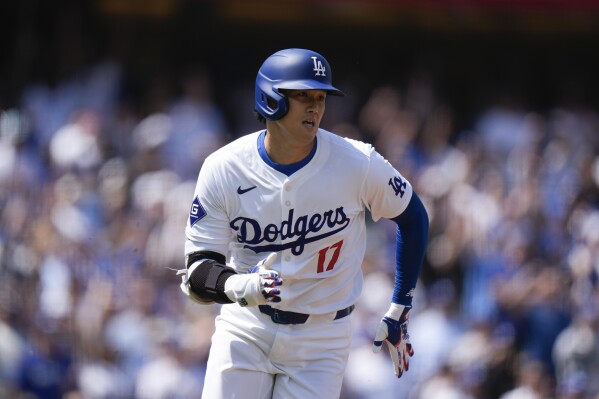 Los Angeles Dodgers' Shohei Ohtani runs to first base after hitting a double against the St. Louis Cardinals during the first inning of a baseball game Thursday, March 28, 2024, in Los Angeles. (AP Photo/Jae C. Hong)