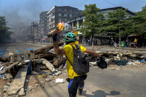 An anti-coup protester throws a molotov cocktail towards police as they move towards the protest area in Yangon, Myanmar Wednesday, March 17, 2021. (AP Photo)