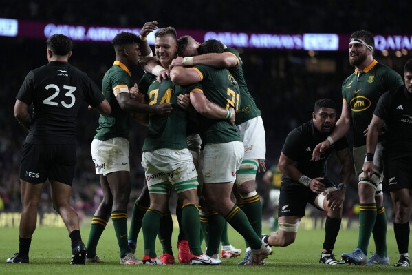 South Africa's Kwagga Smith, centre, celebrates with teammates after scoring a try during the rugby union international match between South Africa and New Zealand, at Twickenham stadium in London, Friday, Aug. 25, 2023. (AP Photo/Alastair Grant)