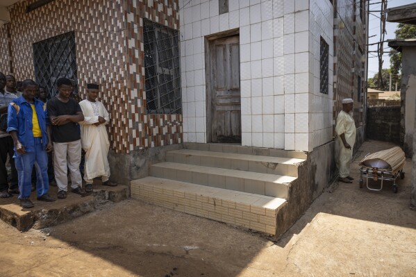 Allassane Sylla, foreground left at center, brother of the late Ousmane Sylla, stands with mourners performing the final funeral prayer outside a mosque in Matoto Bonagui, a suburb of Conakry, Guinea, Tuesday, April 9, 2024. Ousmane died in Italy on Feb. 4, 2024 (AP Photo/Misper Apawu)