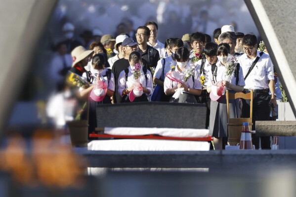 Visitors pay in front of the cenotaph dedicated to the victims of the atomic bombing at the Hiroshima Peace Memorial Park in Hiroshima, western Japan Sunday, Aug. 6, 2023. Hiroshima marked the 78th anniversary of the world's first atomic bombing of the city. (Kyodo News via AP)