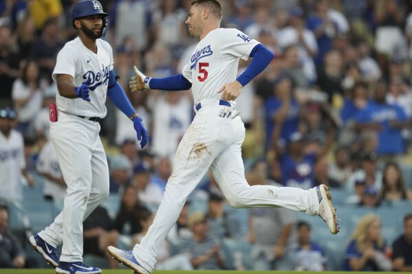 Los Angeles Dodgers' Freddie Freeman (5) celebrates with Amed Rosario after scoring off of a double hit by designated hitter J.D. Martinez during the first inning of a baseball game in Los Angeles, Friday, July 28, 2023. (AP Photo/Ashley Landis)