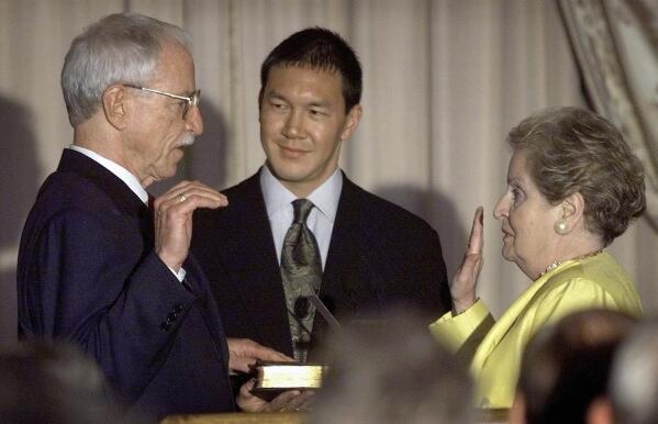 FILE - Secretary of State Madeleine Albright, right, swears in James C. Hormel, left, as the new ambassador to Luxembourg at a State Department ceremony on June 29, 1999, in Washington. Hormel became the nation's first openly gay ambassador. Timothy Wu, center, holds the Bible. Albright has died of cancer, her family said Wednesday, March 23, 2022. (AP Photo/Khue Bui, File)