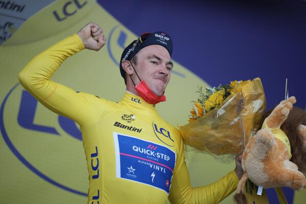 El belga Yves Lampaert celebra en el podio tras ganar la etapa inaugural del Tour de Francia, en Copenhague, Dinamarca, el viernes 1 de julio de 2022. (AP Foto/Daniel Cole)