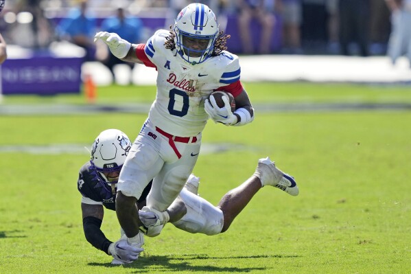 SMU running back Camar Wheaton (0) carries the ball as TCU linebacker Namdi Obiazor (4) tries to tackle him during the first half of an NCAA college football game Saturday, Sept. 23, 2023, in Fort Worth, Texas. (AP Photo/LM Otero)