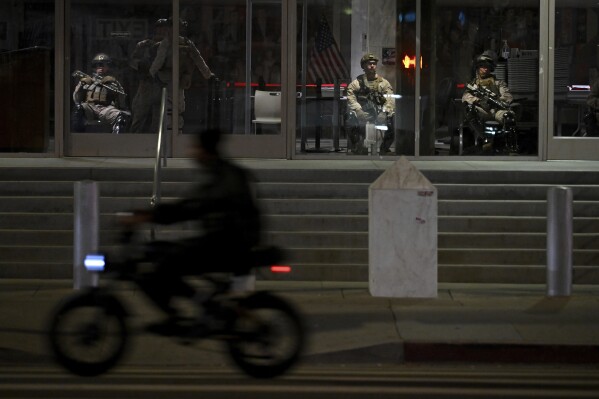 U.S. Marines sit in the lobby while guarding the Robert Young Federal Building Tuesday, June 17, 2025, in Los Angeles. (AP Photo/Wally Skalij)