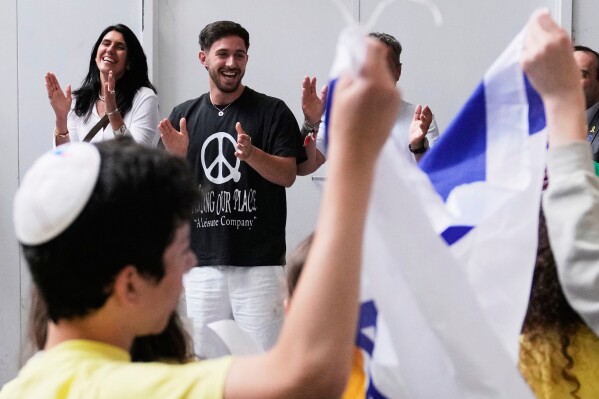 Omer Shem Tov, center, an Israeli hostage who survived over 500 days in Hamas captivity, celebrates while being welcomed during his arrival at Logan Airport, Thursday, May 15, 2025, in Boston. (AP Photo/Charles Krupa)