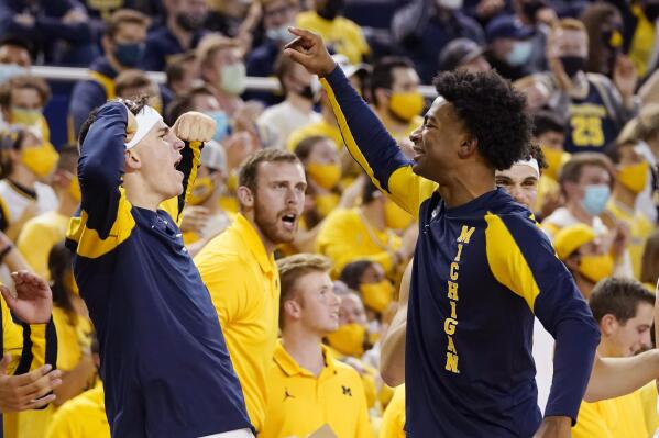 Michigan forward Will Tschetter, left, and guard Jace Howard react after a teammate's basket during the second half of an NCAA college basketball game against Buffalo, Wednesday, Nov. 10, 2021, in Ann Arbor, Mich. (AP Photo/Carlos Osorio)
