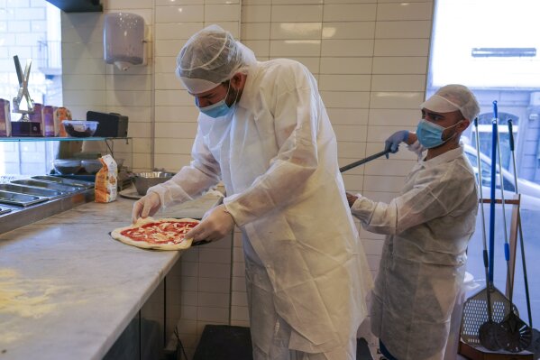Pizzas are being prepared for home delivery at the Caputo pizzeria in Naples, Monday, April 27, 2020. Region Campania allowed cafes and pizzerias to reopen for delivery Monday, after a long precautionary closure due to the coronavirus outbreak. (AP Photo/Andrew Medichini)