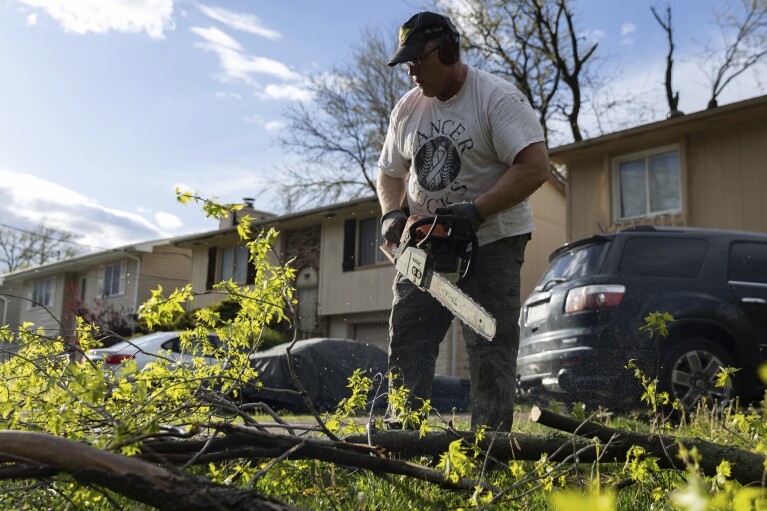 Jim Huff, 53, breaks down fallen trees after a severe storm hit his neighborhood in Council Bluffs, Iowa, on Friday, April 26, 2024. (Anna Reed/Omaha World-Herald via AP)