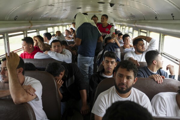 Honduran migrants who were deported from the U.S. sit on a bus after deplaning at Ramon Villeda Morales Airport in San Pedro Sula, Honduras, Wednesday, Dec. 4, 2024. (AP Photo/Moises Castillo)