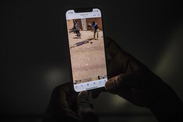 EDS NOTE: GRAPHIC CONTENT - An uncle of a 16-year-old named Adama watches a video in Burkina Faso, Saturday March 18, 2023, showing a man slamming a rock onto the head of his nephew. Burkina Faso has been wracked by violence linked to al-Qaida and the Islamic State group that has killed thousands, but some civilians say they are even more afraid of Burkina Faso’s security forces, whom they accuse of extrajudicial killings. The military junta has denied its security forces were involved, but a frame-by-frame analysis by The Associated Press of the 83-second video shows the killings happened inside a military base in the country's north. (AP Photo)