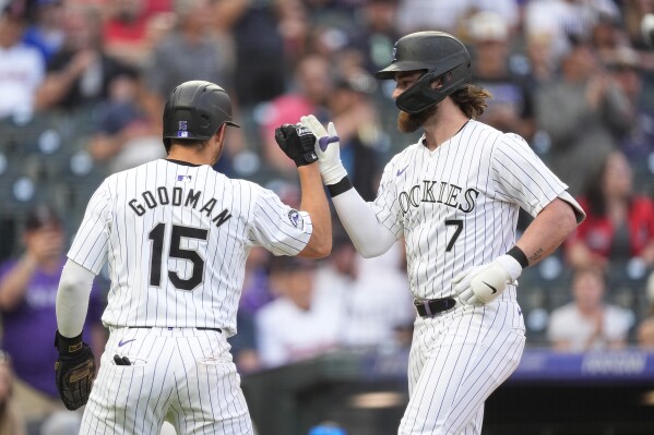 Colorado Rockies' Hunter Goodman, left, congratulates Brendan Rodgers, who hit a two-run home run off Cleveland Guardians starting pitcher Logan Allen during the second inning of a baseball game Wednesday, May 29, 2024, in Denver. (AP Photo/David Zalubowski)