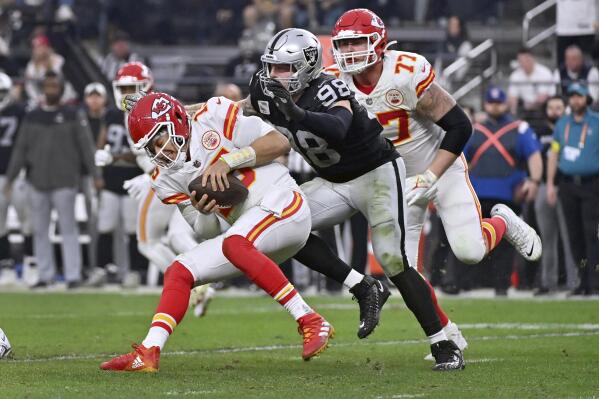 Kansas City Chiefs quarterback Patrick Mahomes (15) is sacked by Las Vegas Raiders defensive end Maxx Crosby (98) as Chiefs guard Andrew Wylie (77) watches during the second half of an NFL football game Saturday, Jan. 7, 2023, in Las Vegas. (AP Photo/David Becker)