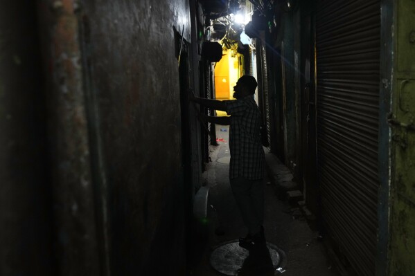Dawn caller Umar Irshad, 53, knocks on the doors of devout Muslims houses to wake them up for pre dawn meal during the holy month of Ramadan in the old quarter of Delhi, India, Tuesday, March, 18, 2025. (AP Photo/Manish Swarup)