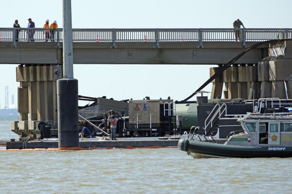 Workers survey the site where a barge crashed into the Pelican Island Bridge, Wednesday, May 15, 2024, in Galveston, Texas. (AP Photo/David J. Phillip)