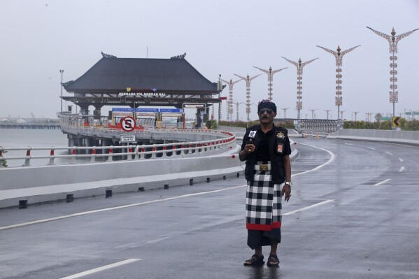 Wayan Widiana, 64, a Balinese traditional guard called "pecalang," patrols a toll road on Nyepi, or Day of Silence, in Bali, Indonesia on Monday, March 11, 2024. Airports closed for 24 hours, the internet was turned off and streets were empty as the predominantly Hindu island of Bali in Muslim-majority Indonesia marked its New Year with an annual Day of Silence, part of six days of extensive New Year rituals. (AP Photo/Firdia Lisnawati)