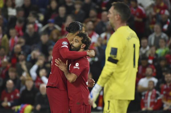Liverpool's Mohamed Salah, centre, celebrates with Liverpool's Virgil van Dijk after scoring his side's second goal from a penalty shot past Rangers' goalkeeper Allan McGregor, right, during the Champions League Group A soccer match between Liverpool and Rangers at Anfield stadium in Liverpool, England, Tuesday Oct. 4, 2022. (AP Photo/Rui Vieira)
